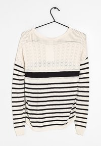 Sweter dziany z szerokim dekoltem, posiadający teksturowaną kremową górę i czarny prążkowany dół. Czarne akcenty w całym projekcie. Miękka tkanina, długie rękawy.