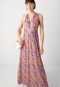 Robe maxi avec un motif zigzag vibrant en rose, jaune et bleu. Fabriquée en tissu léger avec un décolleté en V profond et une conception sans manches.