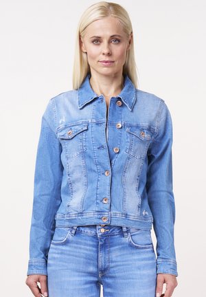 Hellblaue Jeansjacke mit tailliertem Schnitt, doppelt aufgesetzten Brusttaschen und kupferfarbene Knöpfe. Glatte Textur mit leichter Verwaschung.