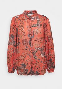 Blouse florale rouge avec un col, des manches bouffantes longues et une fermeture à boutons. Présente des motifs floraux détaillés en bleu marine et marron.