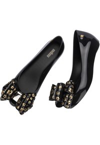 Scarpe flat nere in materiale lucido, caratterizzate da grandi fiocchi con dettagli floreali dorati. Punta rotonda e superficie liscia.