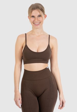 Bruine geribbelde sportbh met dunne bandjes en een brede band, gecombineerd met hoge bruine leggings met een subtiele textuur.