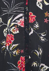 Tissu floral présentant de grandes fleurs rouges et roses sur un fond sombre, avec des feuilles vertes et un accent de dentelle noire au centre.