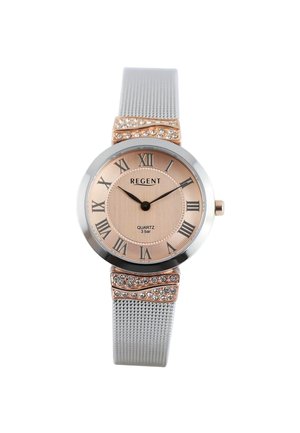 Runde Roségolduhr mit römischen Ziffern, silbernem Mesh-Armband und Kristallakzenten am Armband nahe dem Zifferblatt, zeigt 10:11 Uhr.