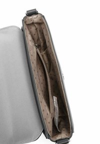 Šedá látková crossbody taška s hladkým, texturovaným povrchem. Interiér má puntíkovaný vzor a zipovou kapsu.