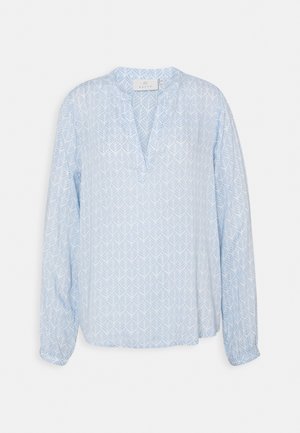Blouse bleu clair à manches longues avec motif de feuilles blanches, col en V et coupe décontractée.