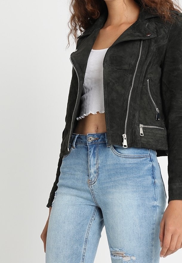 Sort ruskinds bikerjakke med lynlåslommer, en kilekrave og et figursyet design, parret med lyseblå slidte jeans.