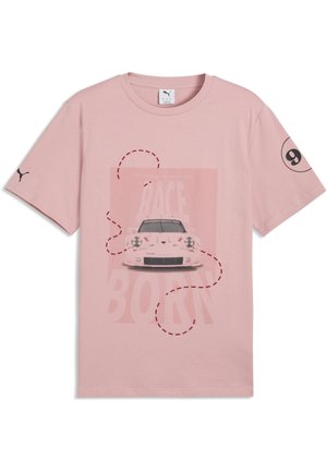 Roze T-shirt met korte mouwen, met een voorkantgrafiek van een raceauto, een gestippelde rode lijn en vervaagde tekst "RACE BORN", Puma-logo op de linkermouw.