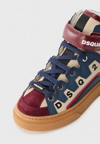 Högskoade sneakers med en blandning av beige, marinblå, vinröd och röda material, med mockadetaljer och kontrasterande snörning.