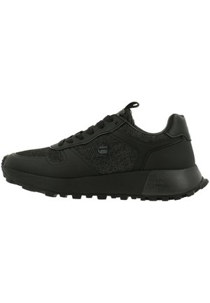 Czarny niski sneaker z fakturowaną tkaniną i syntetycznymi nakładkami, zapinany na sznurowadła, z grubą podeszwą i pętelką na pięcie.