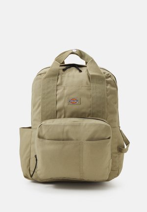 Sac à dos khaki avec des bretelles rembourrées, une poche avant et un logo rond. Fabriqué en tissu durable, avec une poignée supérieure et une poche latérale.