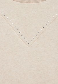 Pullover beige con finitura texture, caratterizzato da un collo a V decorato con borchie argentate disposte in un motivo decorativo.