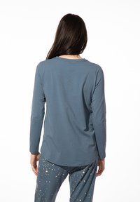 Langsleeve shirt in leisteengroen, met een ronde halslijn en een gladde textuur, gecombineerd met donkere, geruite pyjamabroek.