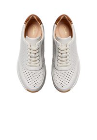Zapatillas blancas perforadas con acentos beige, cordones planos y suela de goma, con una puntera redondeada y plantilla acolchada.