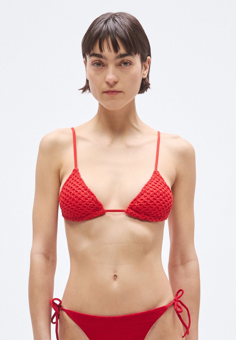 Bikini rojo de crochet con copas triangulares de diseño texturizado, tirantes finos ajustables y parte inferior de talle bajo con lazos laterales.