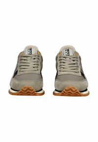 Zapatillas gris claro con materiales de ante y malla. Presentan un panel lateral negro, ojales amarillos y una suela de goma marrón ondulada.