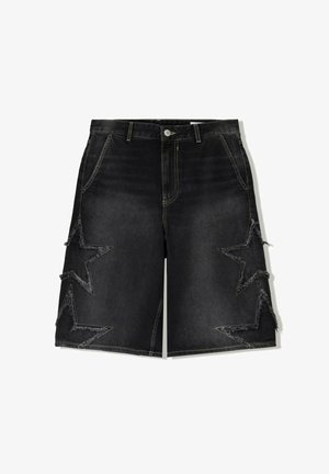 Svarta denimshorts med en avslappnad passform, dekorerade med fransade stjärnmönster på sidorna och kontrasterande gula sömmar.