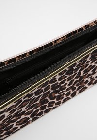 Kabelka s leopardím vzorem a jemnou texturou látky, vybavená dvěma zipovými přihrádkami a akcenty ze zlatého kovu.