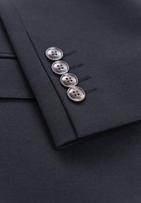 Black suit jacket cuff featuring four metallic buttons with a subtle design, complemented by matching stitching and a smooth fabric texture.