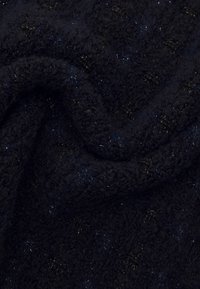 Navy blue textured fabric with a soft, fuzzy quality, featuring subtle sparkles and an intricate pattern of raised accents.