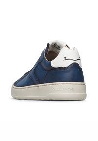 Sneaker in pelle blu e bianca con suola bianca spessa, testo in rilievo "VOILE BLANCHE" sulla suola e design astratto nero sul tab del tallone.