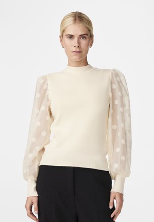 Cream ribbed sweater with sheer, polka-dot puff sleeves and a high neckline. The bottom hem and cuffs are fitted and solid.