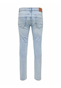 Light blue denim jeans with a slim fit, five-pocket design, and a leather patch at the waistband. Smooth texture, straight cut.