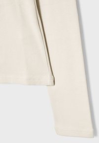 Long-sleeve top made of soft, light beige fabric with a crew neckline, featuring a straight cut and minimal stitching details.