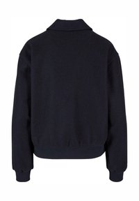 Veste polaire noire à manches longues avec poignets, ourlet côtelés et col replié, vue de dos sur fond blanc.