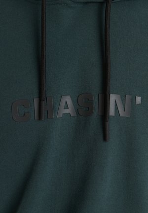 Groene katoenen hoodie met een getextureerd zwart rubberen logo "CHASIN'" op de borst, met zwarte trekkoorden en een gladde stoffen afwerking.