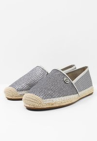 Espadrillas argentate slip-on con toma intrecciata, suola in corda e un accento decorativo del logo. Tessuto morbido con finitura metallica.