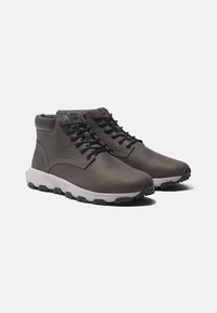 Gray leather ankle boots with black accents, round laces, and a textured midsole. Features a logo on the side and a rugged outsole.