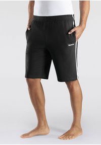 Black athletic shorts with an elastic waistband, side pockets, and white stripes along the sides. Features a small white logo on the front.