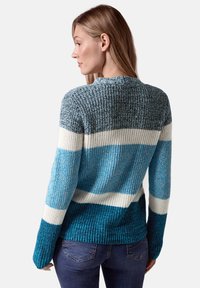 Stickad tröja med blå, teal och vita ränder, texturerat material, rund halsringning och ribbade ärmslut och nederkant.