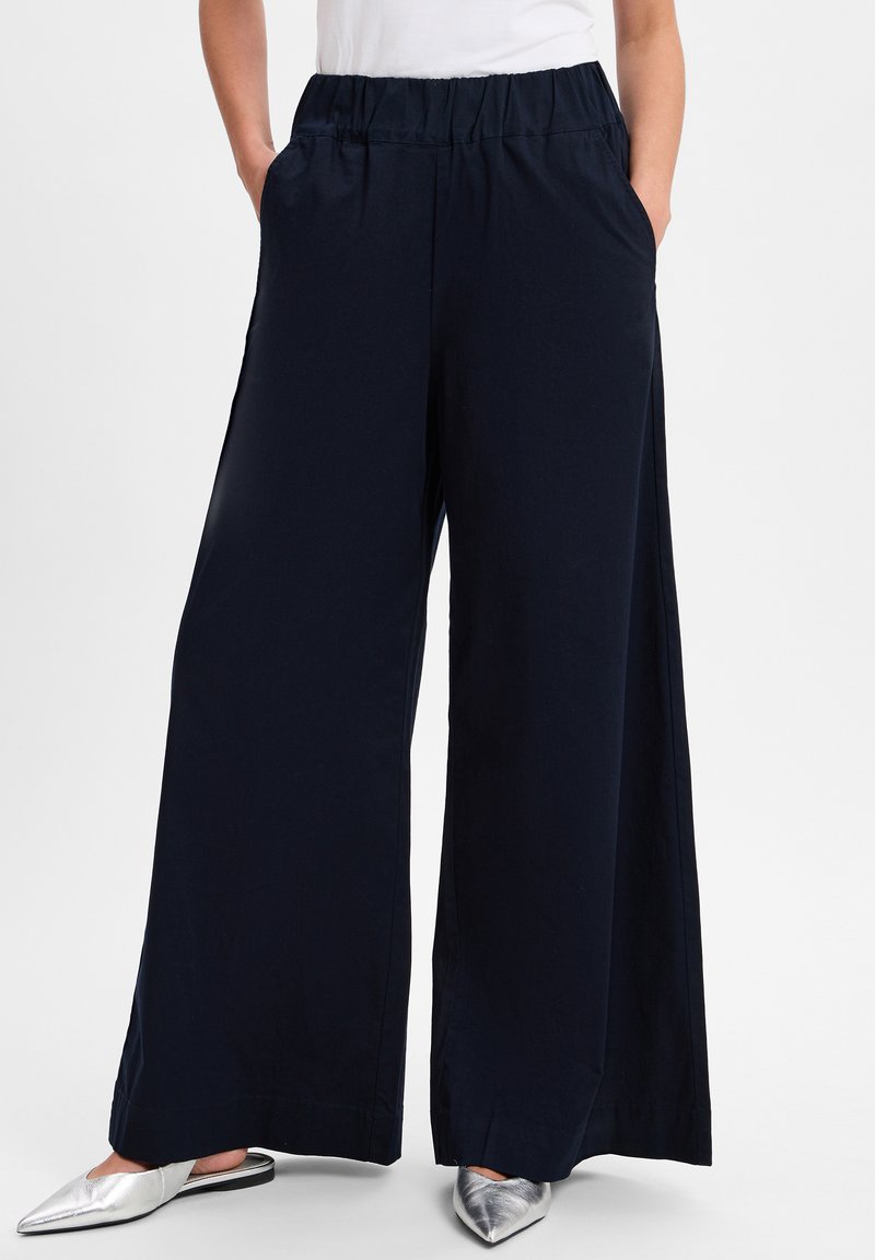 Marineblauwe wijdlopende broeken met een elastische tailleband en zijzakken, gemaakt van zachte stof, met een nette zoom en een minimalistisch ontwerp.