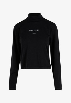 Zwarte lange mouwen turtleneck top gemaakt van zacht materiaal, met een cropped ontwerp en de tekst "LYKKELAND atelier" aan de voorkant in een lichte lettertype.