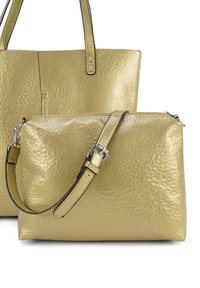 Twee goudkleurige leren handtassen met textuur, een tote met schouderbanden en een kleinere crossbody tas met een verstelbare gespsluiting.