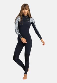 Neopreen outfit in marineblauw met gestreepte witte mouwen. Heeft een hoge hals, een aansluitende pasvorm en versterkte kniestukken voor duurzaamheid.