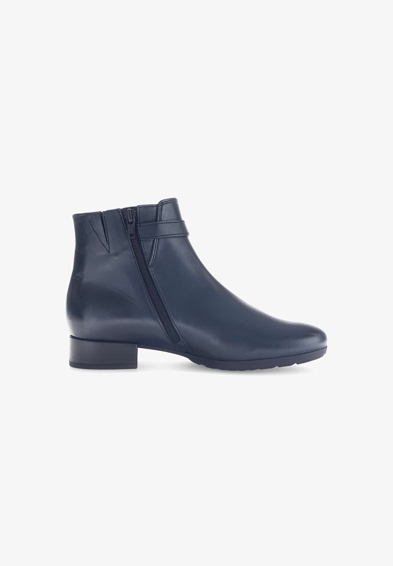 Bottes chelsea en cuir bleu marine avec une fermeture éclair latérale, un petit talon carré et une texture lisse. Présente un design épuré avec des détails de couture minimaux.
