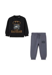 Sudadera negra con gráfico "SOY BATMAN" y pantalones de chándal grises con el logo de Batman. Presenta una cinturilla elástica y tobillos ajustados. Material suave.