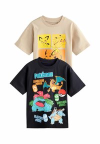 To korteærmede t-shirts: en beige med Pikachu-grafik og en sort med Pokémon-figurer og navne, herunder Charizard og Blastoise.