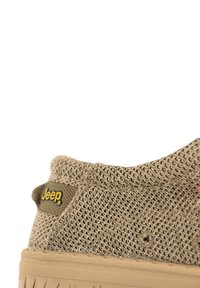 Sneaker in mesh beige con una parte superiore testurizzata, colletto morbido e suola in gomma. Logo Jeep nero e giallo ben visibile sul lato.