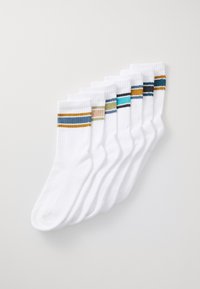 Calzini bianchi di cotone con texture a coste, caratterizzati da vari motivi a strisce colorate in blu, verde, beige, nero e arancione sui polsini.