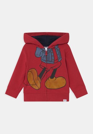 Rode kinderhoodie met ritssluiting aan de voorkant, met een grote afbeelding van een personage dat een spijkerjack en oversized gele schoenen draagt.