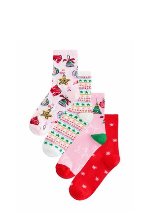 Four colorful Christmas-themed socks with patterns including ornaments, stars, trees, and snowflakes, arranged in a fan on white background.