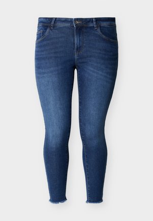 Blaue Skinny-Jeans mit vorderem Knopf- und Reißverschluss, fünf Taschen und ausgefransten Säumen auf hellem, einfachem Hintergrund.