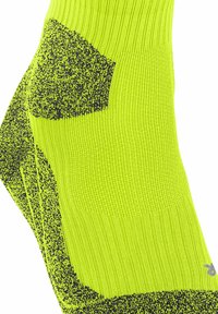 Jasnożółte skarpetki sportowe z teksturowanymi czarnymi akcentami, prążkowanymi sekcjami oraz wzmocnieniami w kluczowych miejscach dla trwałości i wsparcia.