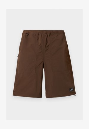 Shorts marron au genou avec ceinture élastique, poches avant, petit détail en boucle et étiquette de marque noire sur l'ourlet.