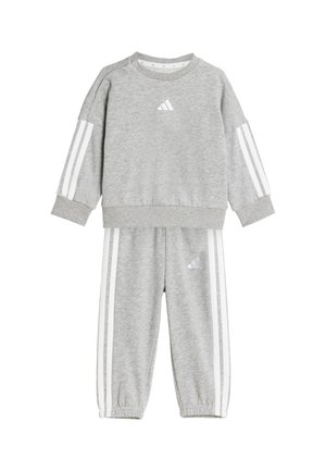 Ensemble de sweat-shirt et pantalon gris, fabriqué en tissu doux. Présente des rayures blanches sur les manches et le pantalon, avec un petit logo sur la poitrine et la cuisse.