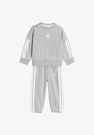 Set din hanorac și pantaloni gri, realizat dintr-un material moale. Prezintă dungi albe pe mâneci și pe pantaloni, cu un mic logo pe piept și pe coapsă.